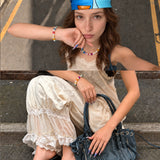 Two-photo collage of a model wearing a rainbow crystal and pearl necklace and matching bracelet with a white outfit.