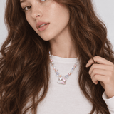 Sweethearts Cat Duo Necklace with pink pearls, iridescent crystals and a cat-pair heart pendant, worn with a white top.