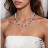 Midnight Prism Pearl Choker with dark gray pearls and iridescent crystal cubes, worn with a white embroidered strapless top.