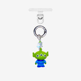 Green three-eyed alien phone charm with a green crystal star and silver-tone attachment hardware, shown on white.