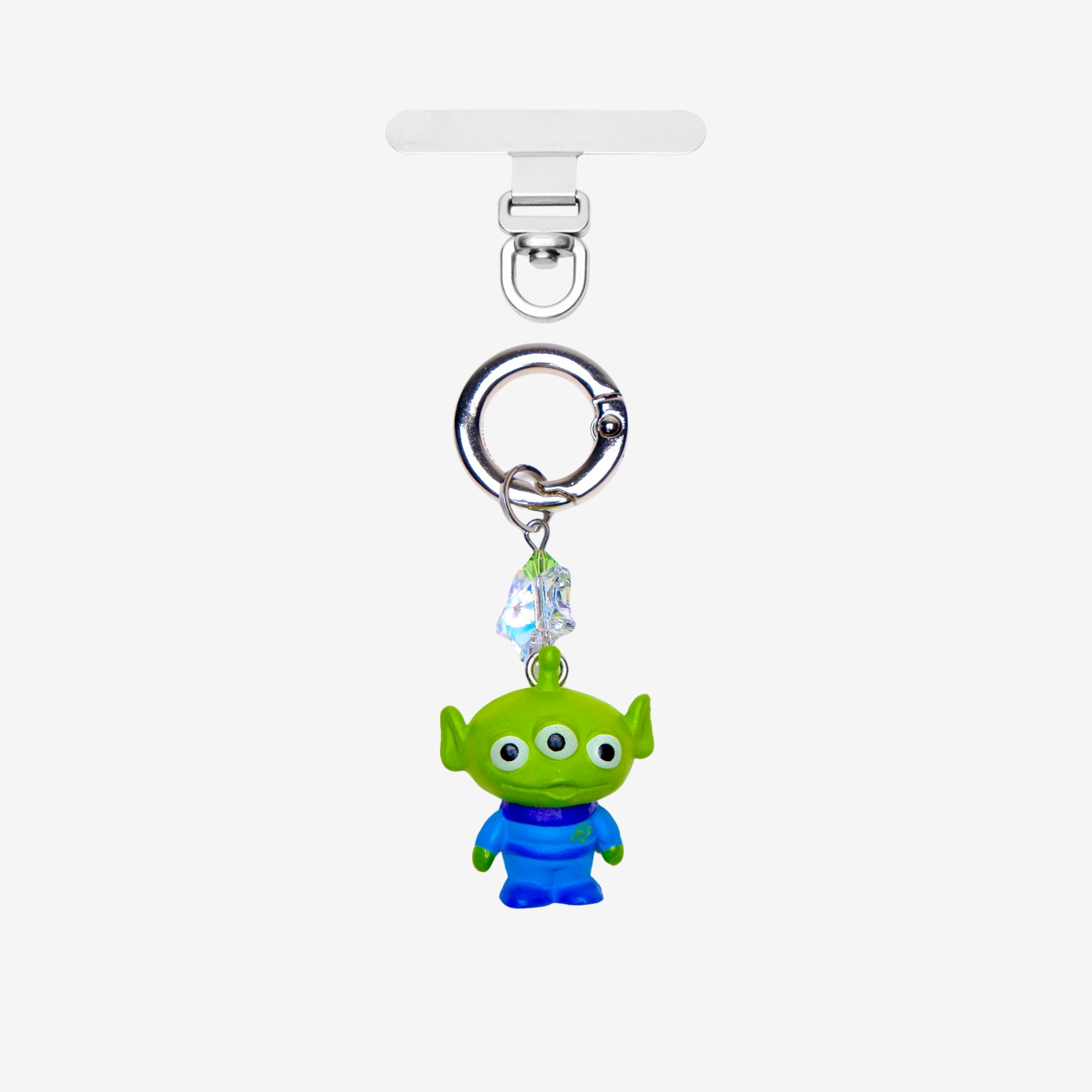 Green three-eyed alien phone charm with a green crystal star and silver-tone attachment hardware, shown on white.