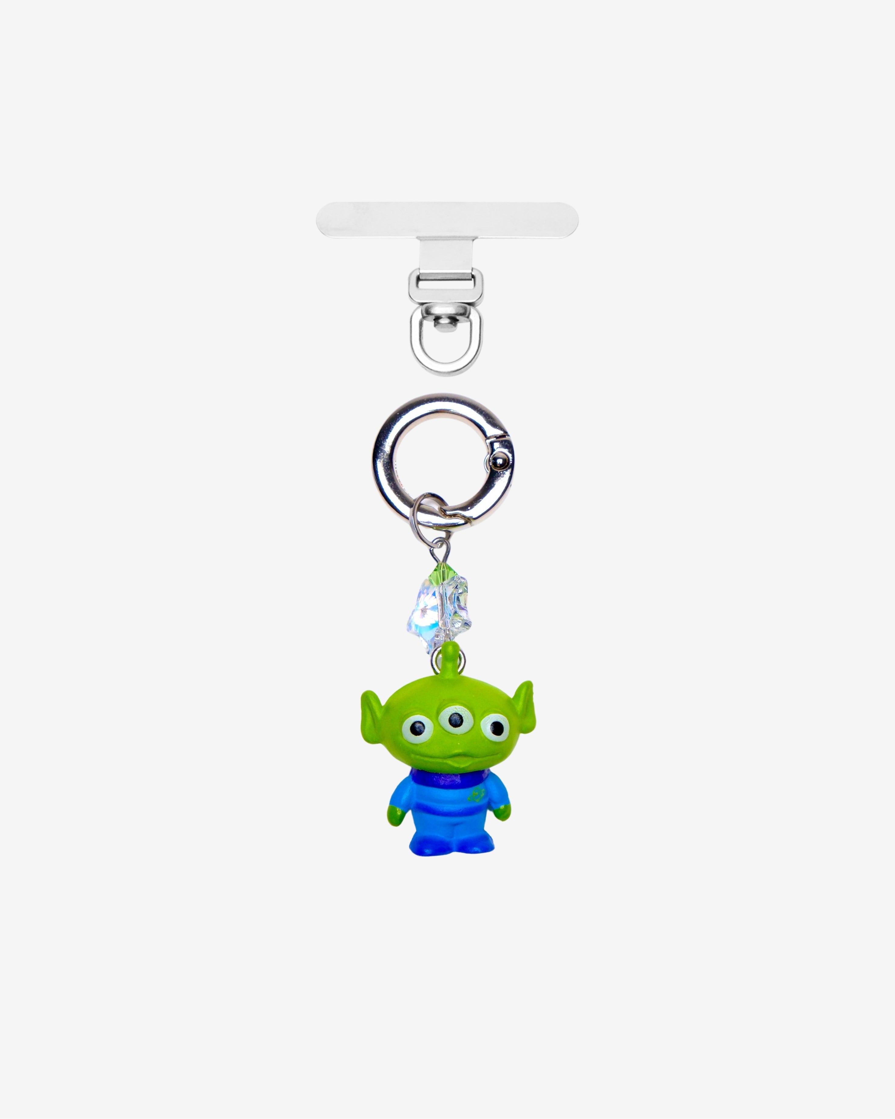 Green three-eyed alien phone charm with a green crystal star and silver-tone attachment hardware, shown on white.