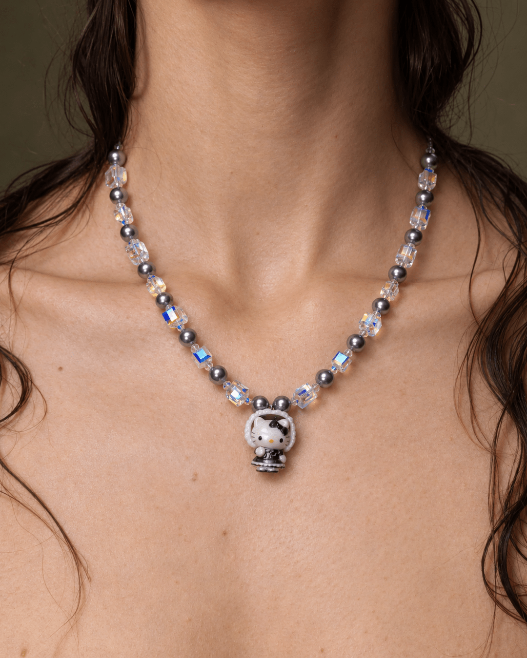 Midnight Bonnet Cat Charm Necklace with gray pearls and iridescent crystal cubes, shown worn around the neck.