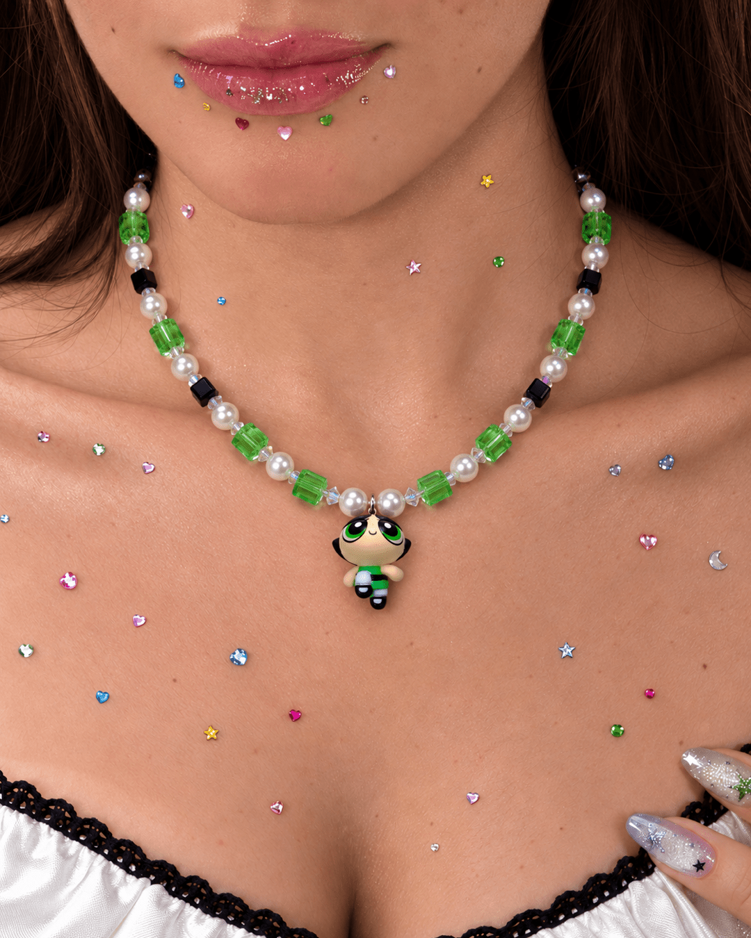 Green Force Charm Necklace with green and black crystals, white pearls and a girl pendant, worn above a lace-trimmed top.