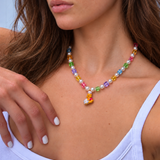Honey Baker Charm Necklace with rainbow crystal cubes, white pearls and a bear chef pendant, worn with a pale tank top.