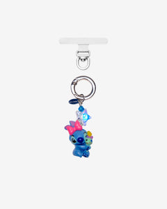 Detachable phone charm with a blue creature wearing a pink bow, a smaller colorful figure, blue crystals and a silver-tone ring.