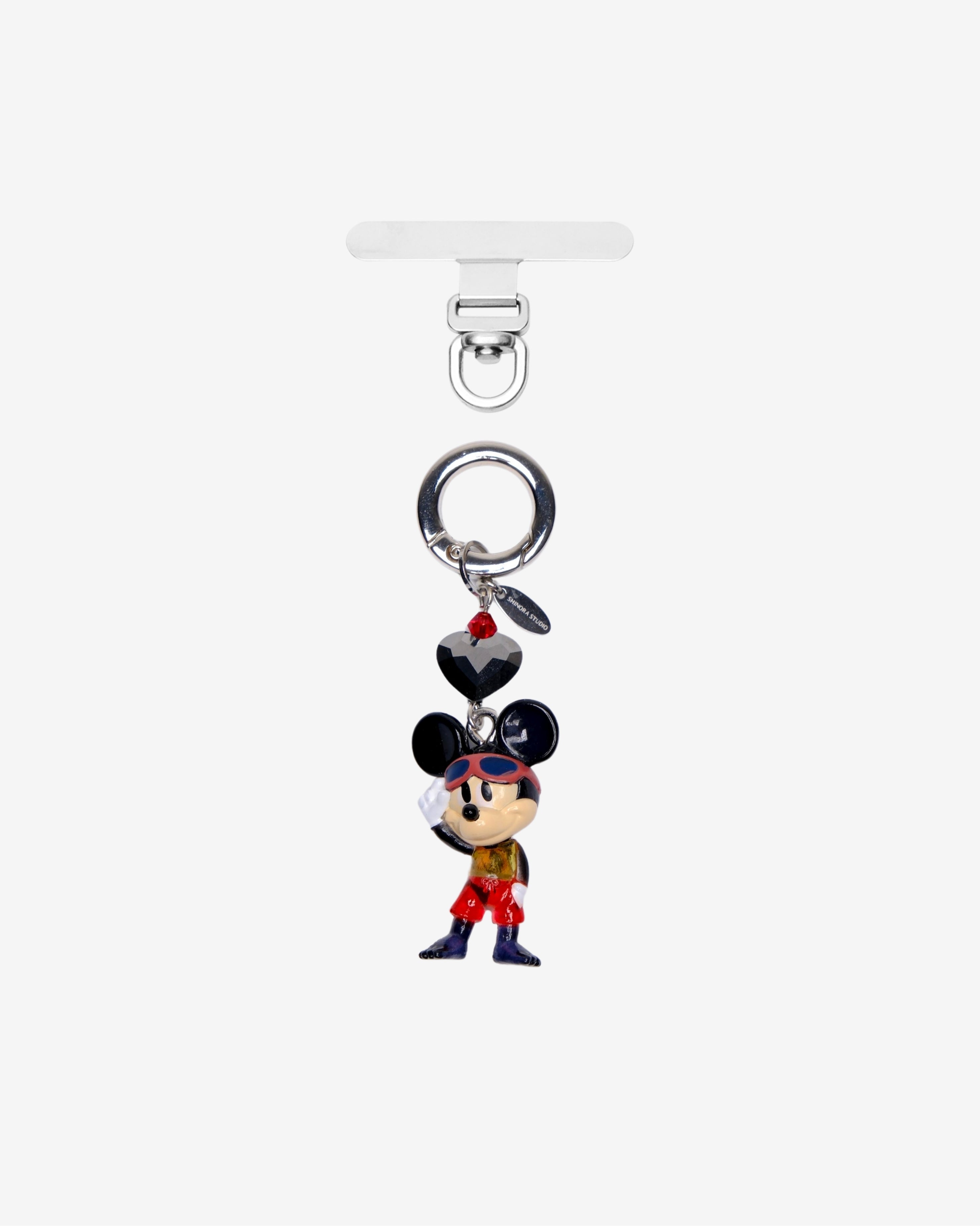 Black-eared mouse character phone charm in red trousers, with dark crystal accents and a silver attachment ring.