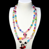 Rainbow crystal and pearl witch mouse necklace layered above a red-caped vampire mouse necklace on a white bust.
