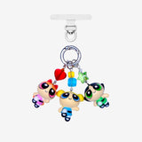 Three detachable phone charms with cartoon girl figures in pink, blue and green, colorful crystals and silver-tone rings.