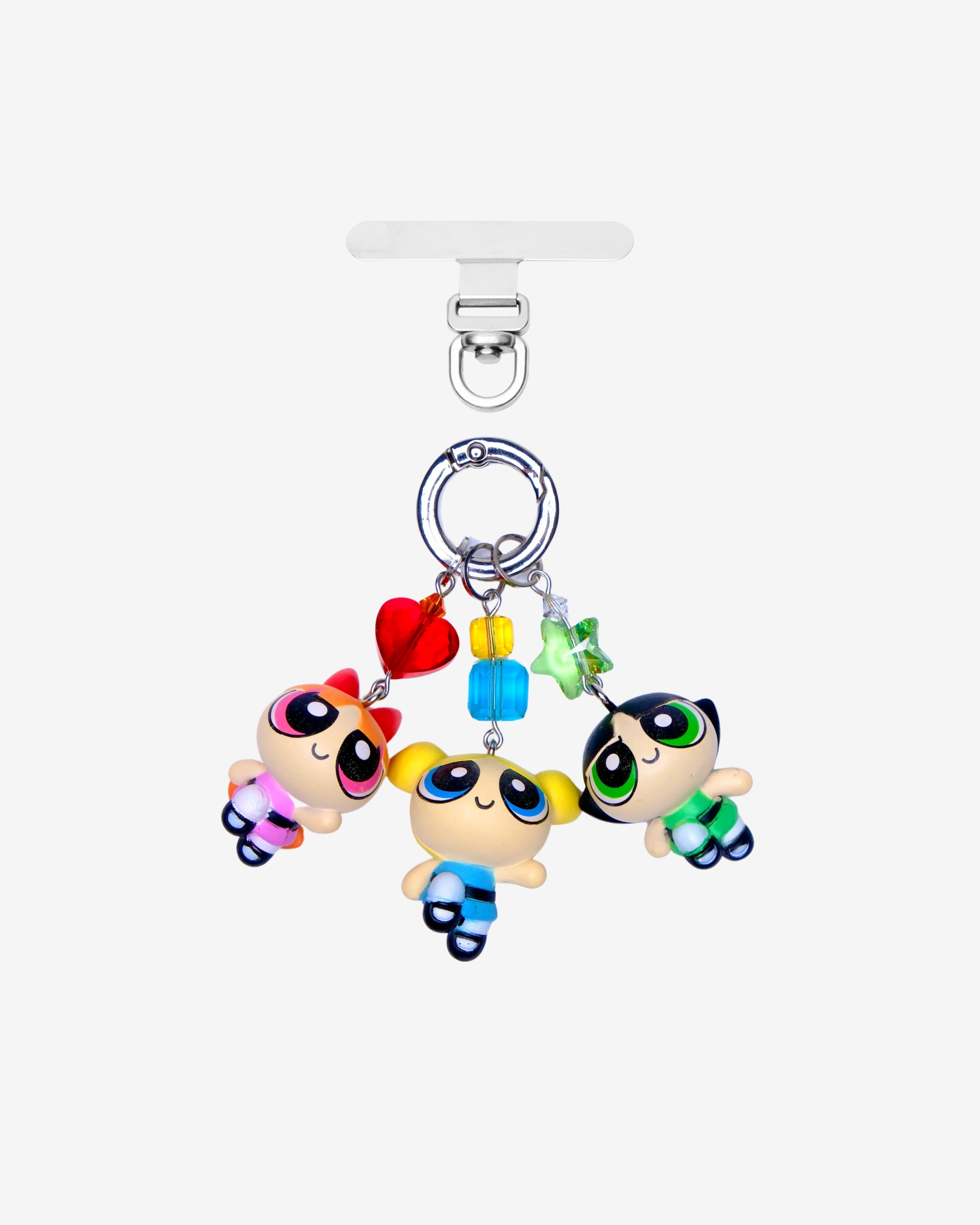 Three detachable phone charms with cartoon girl figures in pink, blue and green, colorful crystals and silver-tone rings.