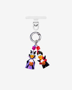 Detachable phone charm with two duck figures in Halloween costumes, pumpkin details, purple and red crystals and a silver-tone ring.