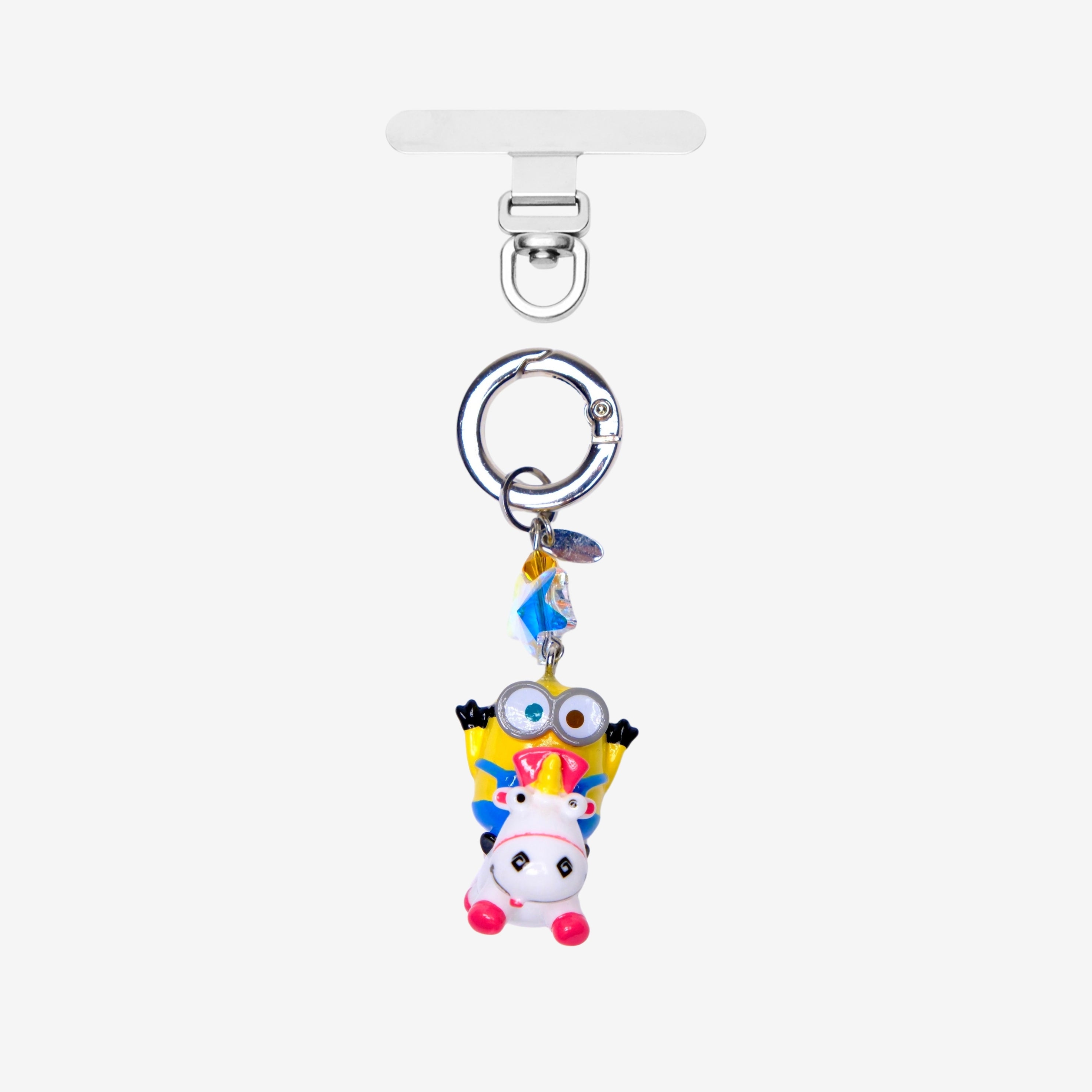 Detachable phone charm with a yellow goggled figure riding a white unicorn, colorful crystals and a silver-tone ring.