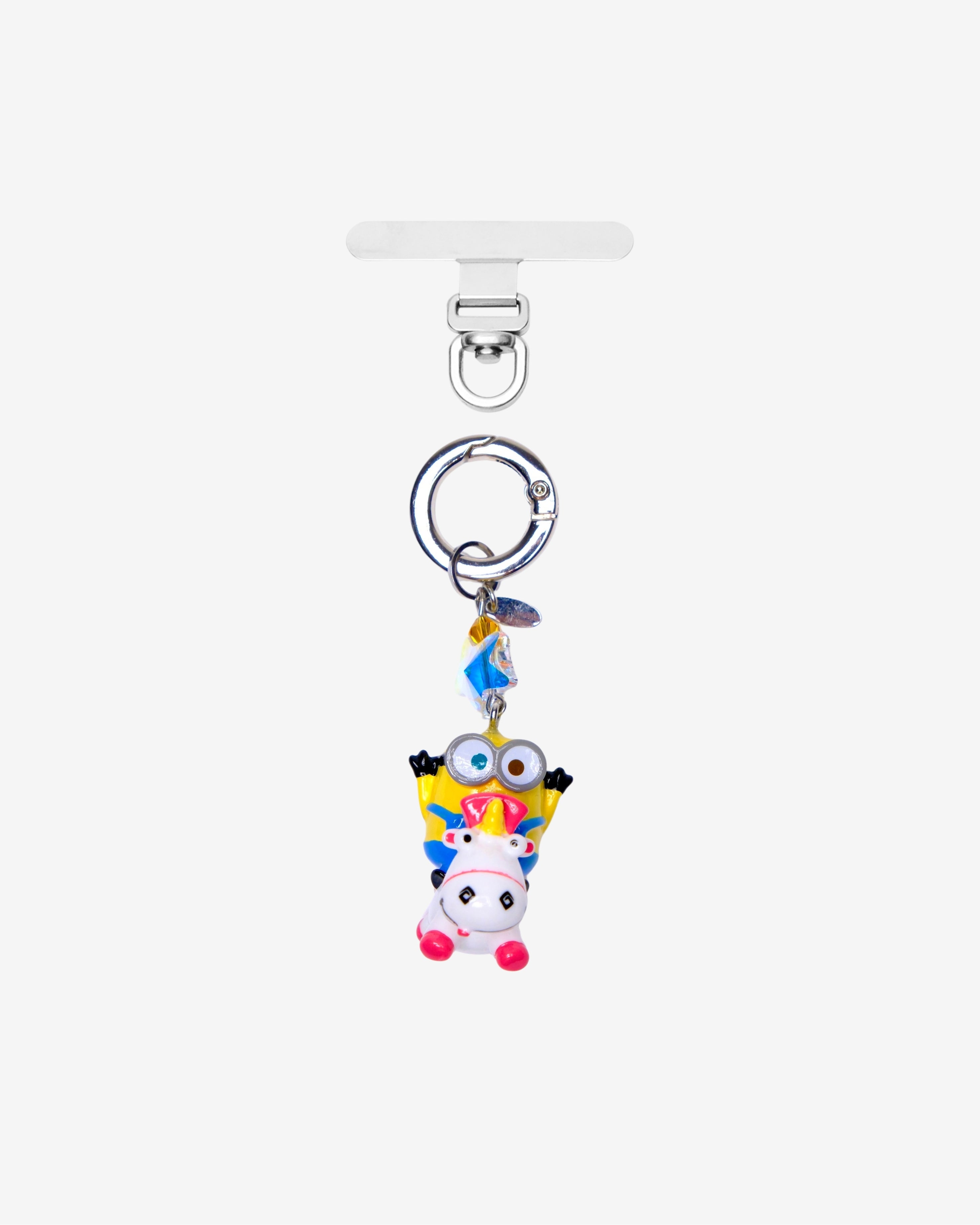 Detachable phone charm with a yellow goggled figure riding a white unicorn, colorful crystals and a silver-tone ring.