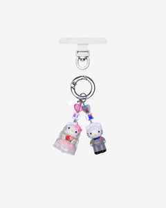 Detachable phone charm with two white cat figures in wedding outfits, pink and iridescent crystals and a silver-tone ring.