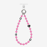 Pink crystal beaded phone chain with a black heart, dark geometric beads and silver-tone attachment rings.