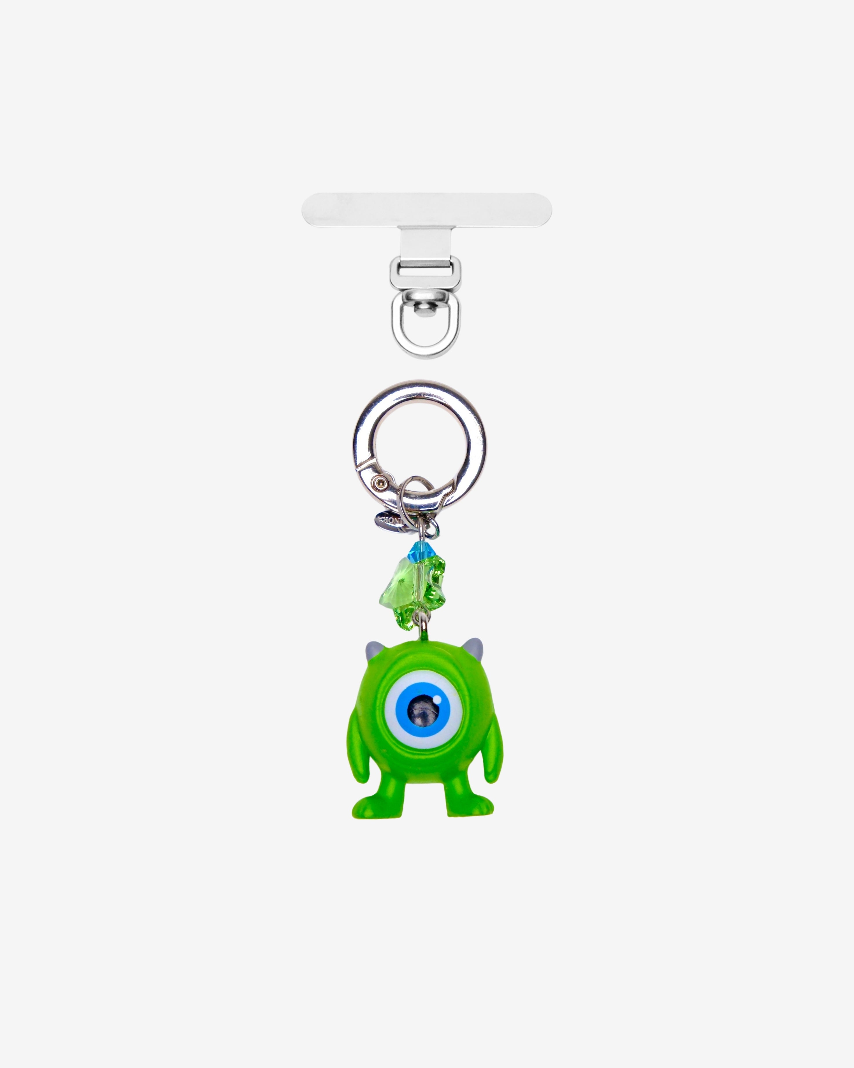 Lime green one-eyed monster phone charm with a green crystal star and silver-tone attachment hardware on white.