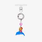 Detachable phone charm with a cat figure riding a blue dolphin, a pink heart crystal and a silver-tone ring.