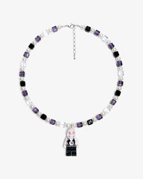Studio product photo of a handmade pastel crystal charm necklace with white pearl accents and a playful vintage-inspired pendant.