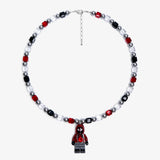 Studio product photo of a handmade red, black, and clear crystal charm necklace with pearl accents and a city-inspired collectible pendant.