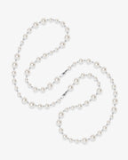 Handmade Swarovski pearl necklace opera length with graduating white pearls and silver chain - flat lay