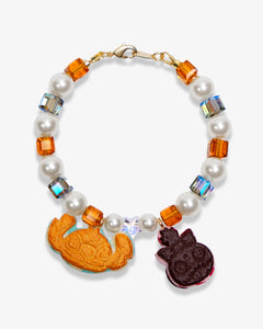 Studio product photo of a handmade cookie Swarovski crystal charm bracelet with pearls and vintage-inspired charm details.