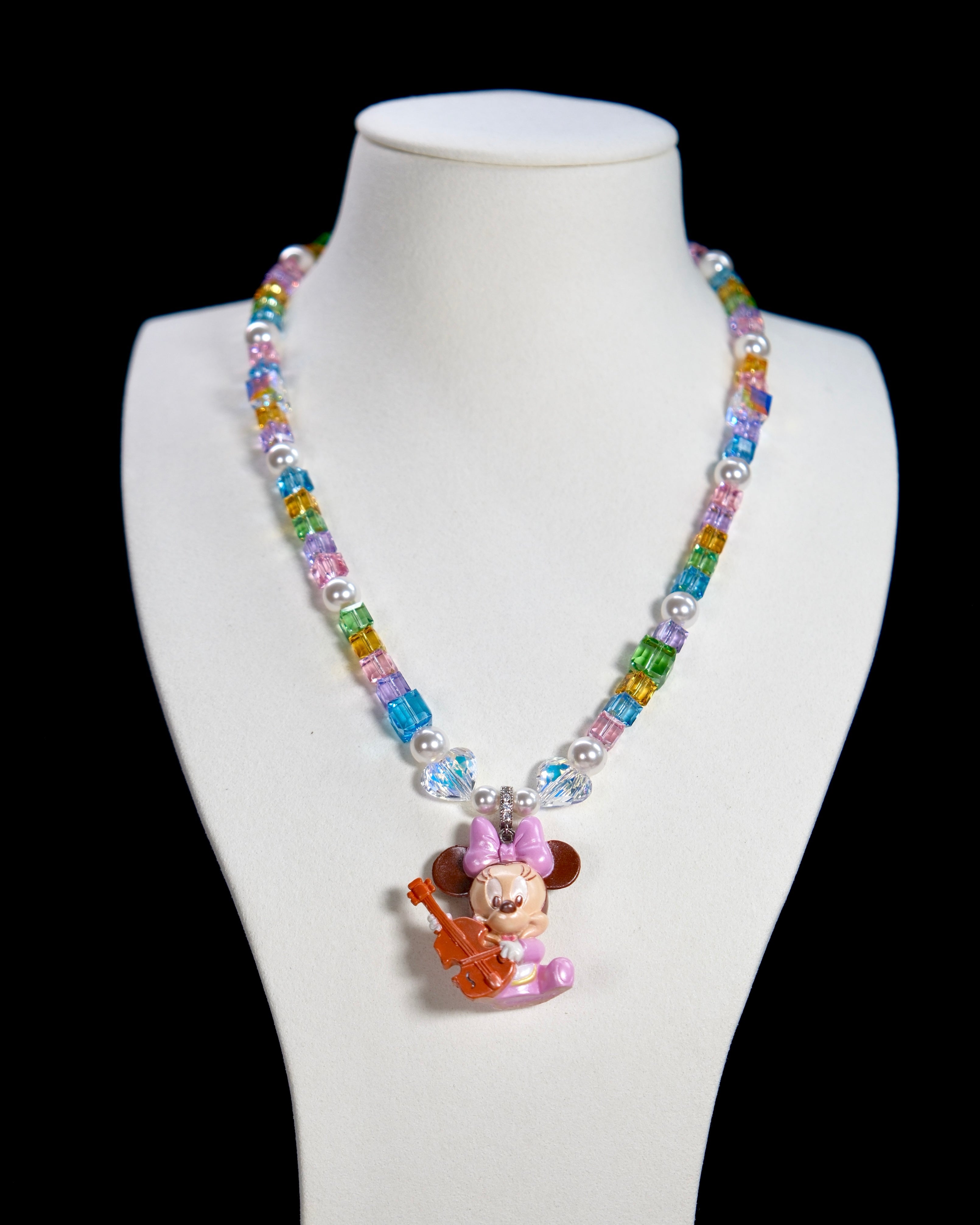 Close-up detail of a handmade rainbow Swarovski crystal charm necklace with pearls and vintage-inspired charm details.