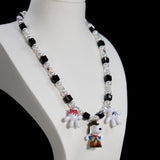 Close-up detail of a handmade colorful Swarovski crystal charm necklace with pearls and vintage-inspired charm details.
