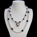 Close-up detail of a handmade black Swarovski crystal charm necklace with pearls and vintage-inspired charm details.