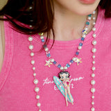Close-up detail of a handmade pink Swarovski crystal charm necklace with pearls and vintage-inspired charm details.