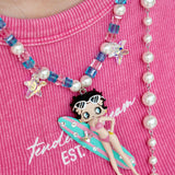 Close-up detail of a handmade pink Swarovski crystal charm necklace with pearls and vintage-inspired charm details.