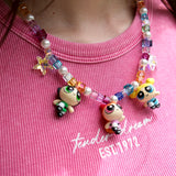 Close-up detail of a handmade colorful Swarovski crystal charm necklace with pearls and vintage-inspired charm details.
