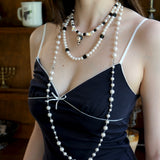Close-up detail of a handmade black Swarovski crystal charm necklace with pearls and vintage-inspired charm details.