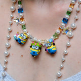 Close-up detail of a handmade colorful Swarovski crystal charm necklace with pearls and vintage-inspired charm details.
