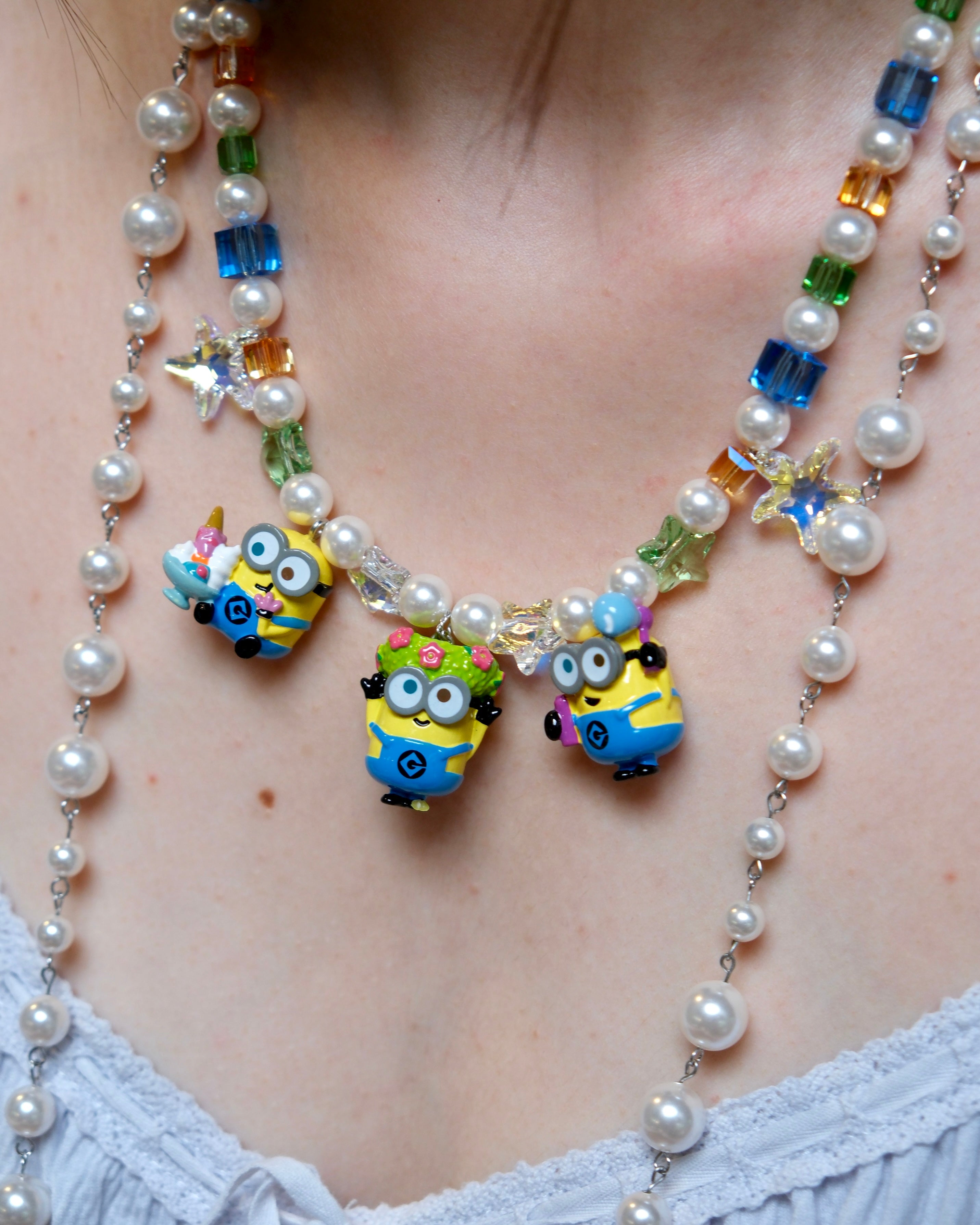 Close-up detail of a handmade colorful Swarovski crystal charm necklace with pearls and vintage-inspired charm details.