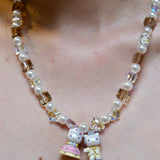 Close-up detail of a handmade colorful Swarovski crystal charm necklace with pearls and vintage-inspired charm details.