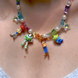 Close-up detail of a handmade rainbow Swarovski crystal charm necklace with pearls and vintage-inspired charm details.