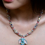 Detailed view of a handmade blue elephant charm necklace with gray Swarovski pearls, pink beads, and iridescent crystal accents.