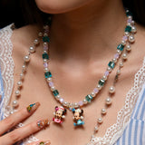 Close-up of a handmade pastel Swarovski crystal charm necklace with pink and blue beads, pearl accents, and nostalgic collectible charms.