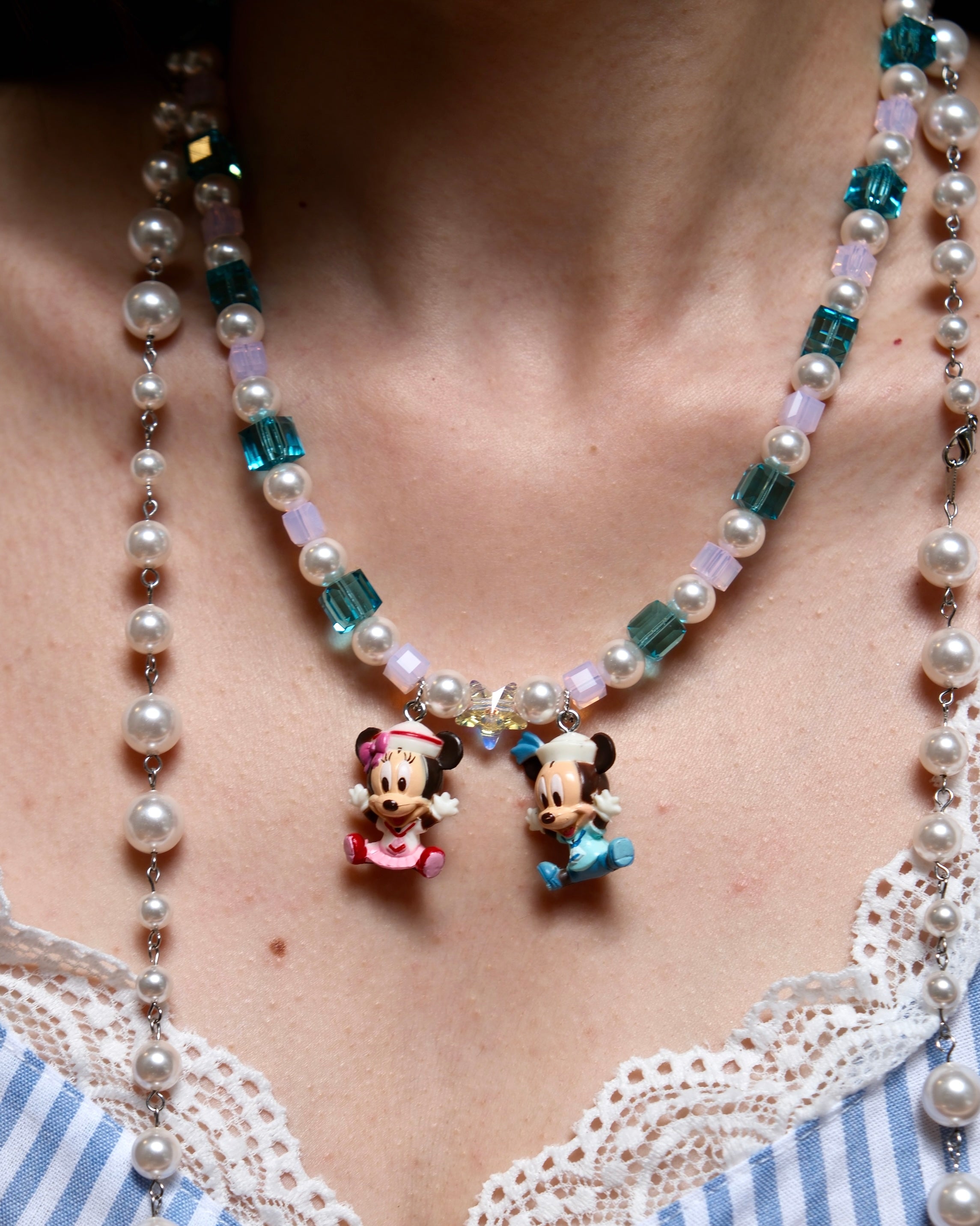 Detailed view of a handmade pastel Swarovski crystal charm necklace with pink and blue beads, pearl accents, and nostalgic collectible charms.