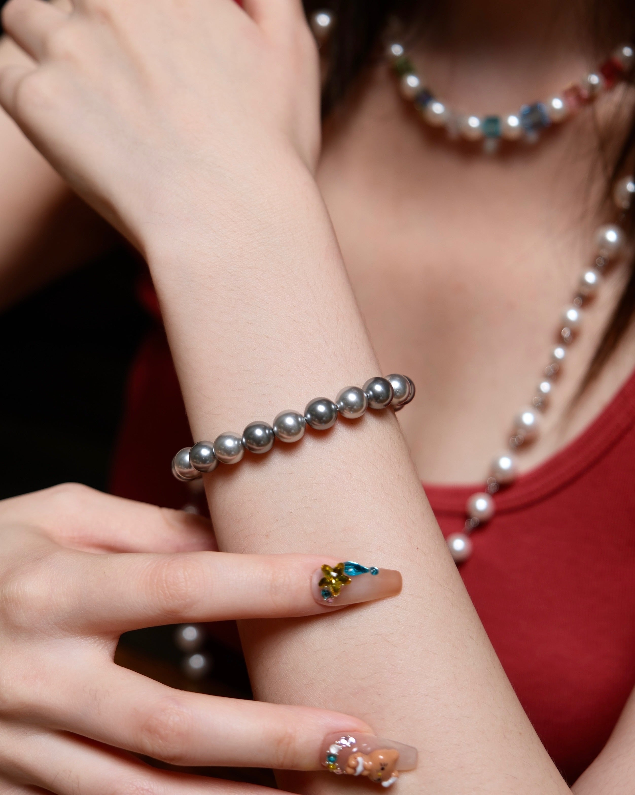 Model wearing a handmade charcoal gray Swarovski pearl bracelet in a monochrome jewelry look.