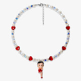 Studio product photo of a handmade red heart charm necklace with white Swarovski crystal pearls and iridescent cube beads.