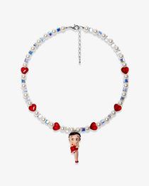 Studio product photo of a handmade red heart charm necklace with white Swarovski crystal pearls and iridescent cube beads.