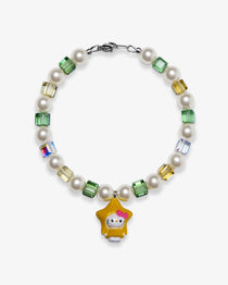 Studio product photo of a handmade yellow star charm bracelet with white Swarovski pearls and green, gold, and iridescent crystal beads.