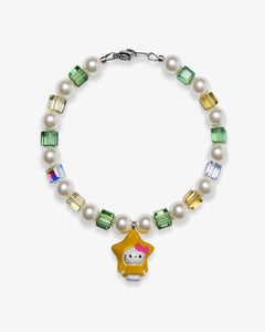 Studio product photo of a handmade yellow star charm bracelet with white Swarovski pearls and green, gold, and iridescent crystal beads.