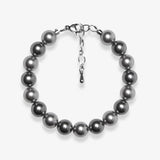 Studio product photo of a handmade charcoal gray Swarovski pearl bracelet with a silver clasp and adjustable extender chain.