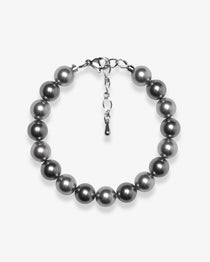 Studio product photo of a handmade charcoal gray Swarovski pearl bracelet with a silver clasp and adjustable extender chain.