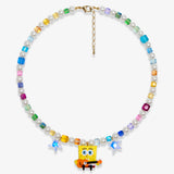 Studio product photo showing Rainbow Swarovski crystal and pearl charm necklace with a vintage guitar-playing character-inspired pendant and blue star accents.