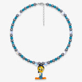 Studio product photo showing Blue and charcoal Swarovski crystal pearl charm necklace with a vintage yellow bird-inspired pendant.