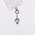 Product photo showing Green character-inspired phone charm with a green crystal accent and silver-tone phone hardware.