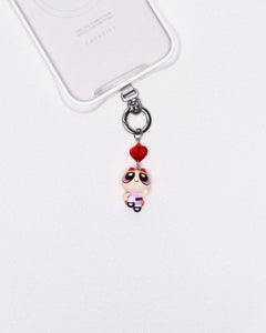 Product photo showing Pink character-inspired phone charm with a red crystal heart and silver-tone phone hardware.